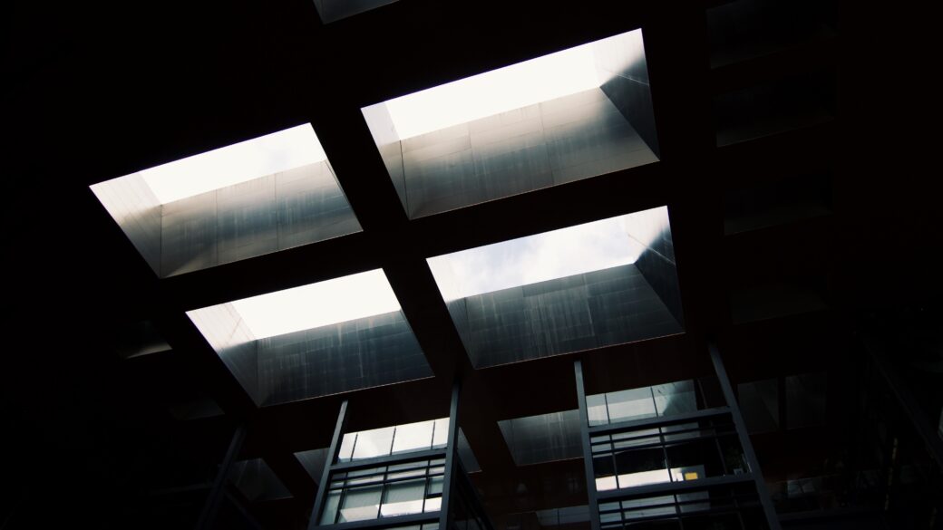 The stark contrast of the black and white architecture stands in sharp relief against a backdrop of darkness, illuminated by sparse pools of light.