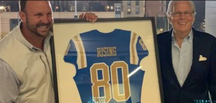 Nelson C. Rising receiving a UCLA Bruin jersey bearing the number 80