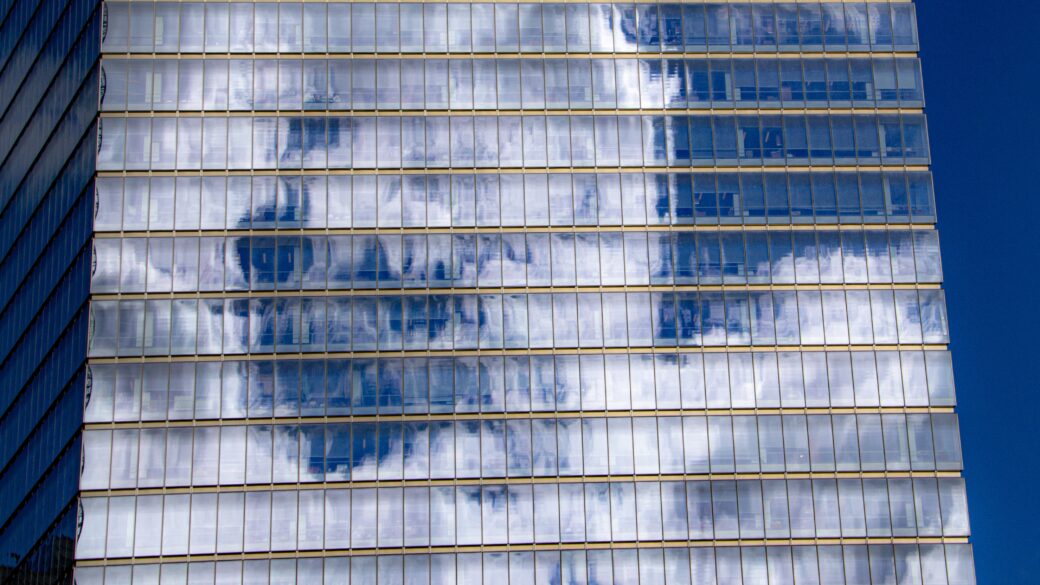 Clouds and sky reflecting off the windows of a glass high-rise