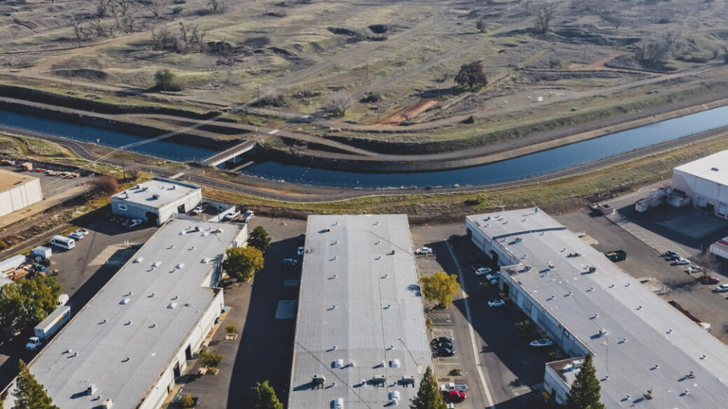 Aerial view of Sacramento Industrial Park with a river and undeveloped land in the background.