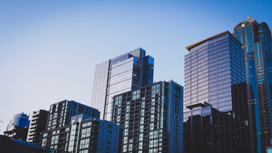 Photo from below looking up at cityscape skyline mix of multi-tenant buildings and office buildings.